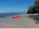 Tranquil beach scene with two bright red kayaks sitting in the sand on the shore at 854 Sky Loch N Dr, Dunedin, FL 34698