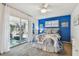 Bright bedroom with accent wall, white furniture, and access to a screened-in patio at 854 Sky Loch N Dr, Dunedin, FL 34698