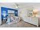 Comfortable bedroom with blue accent wall, white furniture, and nautical themed decor at 854 Sky Loch N Dr, Dunedin, FL 34698