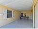 Spacious carport area with an inviting seating arrangement near the front door at 854 Sky Loch N Dr, Dunedin, FL 34698