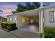 Charming home featuring a covered carport with seating and manicured landscaping, offering a warm and inviting curb appeal at 854 Sky Loch N Dr, Dunedin, FL 34698