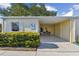 Charming villa featuring a covered carport and well-maintained landscaping under a clear blue sky at 854 Sky Loch N Dr, Dunedin, FL 34698