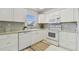 Bright kitchen featuring white cabinets, modern appliances, and decorative tile backsplash at 854 Sky Loch N Dr, Dunedin, FL 34698