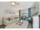 Bright living room with a sliding glass door to the lanai, fireplace, and coastal decor at 854 Sky Loch N Dr, Dunedin, FL 34698