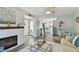 Bright open-concept living room with fireplace, coastal accents, and view to kitchen at 854 Sky Loch N Dr, Dunedin, FL 34698