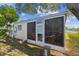 Enclosed sunroom featuring full screens and a separate entrance door at 854 Sky Loch N Dr, Dunedin, FL 34698