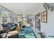 Bright sunroom with comfortable seating, fan, rug, and access to the outside at 854 Sky Loch N Dr, Dunedin, FL 34698
