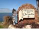 A welcome to Dunedin sign featuring a statue of a Scottish bagpiper on the waterfront at 854 Sky Loch N Dr, Dunedin, FL 34698