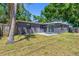 Spacious backyard with a gray house and a sliding glass door to the patio at 8648 78Th Pl, Seminole, FL 33777