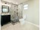 Updated bathroom featuring tiled walk-in shower, unique black vanity with marble top, and modern lighting at 8648 78Th Pl, Seminole, FL 33777