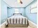Cozy bedroom with blue walls, a ceiling fan, and natural light from the windows at 8648 78Th Pl, Seminole, FL 33777