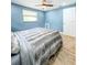 Bedroom with wood-look flooring, neutral walls, and a window with blinds at 8648 78Th Pl, Seminole, FL 33777