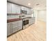 Modern kitchen with stainless steel appliances, gray cabinets, butcher block countertops, and wood-look tile floors at 8648 78Th Pl, Seminole, FL 33777