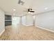 Spacious living room with wood-look tile flooring, neutral paint, updated lighting, and easy access to other rooms at 8648 78Th Pl, Seminole, FL 33777