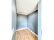 Small, empty room with wood-look flooring, blue walls, and neutral baseboards at 8648 78Th Pl, Seminole, FL 33777
