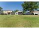 Wide backyard view featuring the screen lanai with large grassy area at 5754 Sweet William Ter, Land O Lakes, FL 34639