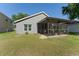 Exterior view of a screened-in lanai in a backyard with green grass, offering a peaceful outdoor space at 5754 Sweet William Ter, Land O Lakes, FL 34639