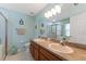 Bathroom featuring double sinks, walk-in shower, and a serene color palette at 5754 Sweet William Ter, Land O Lakes, FL 34639