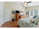 Comfortable bedroom with hardwood floors, ceiling fan, and a light and airy feel at 5754 Sweet William Ter, Land O Lakes, FL 34639