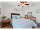 Bright bedroom featuring hardwood floors, ceiling fan, and a decorative headboard at 5754 Sweet William Ter, Land O Lakes, FL 34639