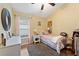 Cozy bedroom with soft lighting, a window with blinds, and hardwood floors at 5754 Sweet William Ter, Land O Lakes, FL 34639