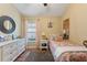 Well-lit bedroom featuring hardwood floors, a window, and dresser with a mirror at 5754 Sweet William Ter, Land O Lakes, FL 34639