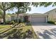 Charming single-story home with a gray exterior, lush landscaping, and an attached two-car garage at 5754 Sweet William Ter, Land O Lakes, FL 34639