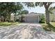 Charming single-story home with a gray exterior, lush landscaping, and an attached two-car garage at 5754 Sweet William Ter, Land O Lakes, FL 34639
