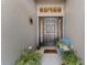 Welcoming front entrance with a dark door, decorative accents, and a cozy chair with greenery at 5754 Sweet William Ter, Land O Lakes, FL 34639