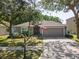 Charming home exterior featuring a well-manicured lawn and two-car garage at 5754 Sweet William Ter, Land O Lakes, FL 34639