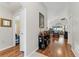 Hallway with hardwood floors, leading to the living area, decorated with tasteful accents and warm lighting at 5754 Sweet William Ter, Land O Lakes, FL 34639