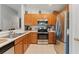 Modern kitchen with stainless steel appliances, wood cabinets, and a breakfast bar at 5754 Sweet William Ter, Land O Lakes, FL 34639
