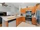 Well-equipped kitchen with stainless steel appliances, wood cabinets, and a breakfast bar overlooking the living area at 5754 Sweet William Ter, Land O Lakes, FL 34639