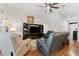 Inviting living room with wood floors, ceiling fan, and a modern entertainment center at 5754 Sweet William Ter, Land O Lakes, FL 34639