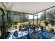 Enclosed back patio featuring a dining table, chairs, and view of the yard at 5754 Sweet William Ter, Land O Lakes, FL 34639