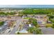 Aerial view shows a charming lakeside property, with solar panels, and an expansive driveway amidst mature trees and a serene water view at 1023 Springtime Dr, Holiday, FL 34691