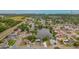This aerial shot displays a serene lakefront home surrounded by lush trees, showcasing the waterfront and peaceful neighborhood at 1023 Springtime Dr, Holiday, FL 34691