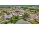 This aerial view reveals a lakeside home with a screened-in pool, lush landscaping, and a private dock for waterfront living at 1023 Springtime Dr, Holiday, FL 34691