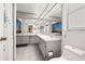 Large bathroom featuring double sinks, bright lighting, and neutral tiling at 1023 Springtime Dr, Holiday, FL 34691
