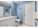 Bright blue bathroom with white vanity, marble countertop, and updated fixtures at 1023 Springtime Dr, Holiday, FL 34691