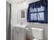 Bathroom with gray vanity, toilet, and blue curtain at 1023 Springtime Dr, Holiday, FL 34691