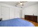 Bedroom featuring hardwood floors, ceiling fan, closet, and dark furniture at 1023 Springtime Dr, Holiday, FL 34691