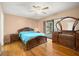 Bright bedroom with wood floors, dresser, and sliding glass doors to the backyard at 1023 Springtime Dr, Holiday, FL 34691