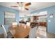 Dining room with open view into the living room and kitchen featuring a ceiling fan and large window at 1023 Springtime Dr, Holiday, FL 34691