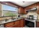 Close-up of kitchen area featuring stainless steel appliances, granite countertop, and a window with natural light at 1023 Springtime Dr, Holiday, FL 34691