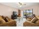 Comfortable living room with sofas, a TV, and glass doors leading to a lanai at 1023 Springtime Dr, Holiday, FL 34691