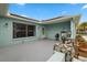 A welcoming light-blue porch with stone pillars, stylish lighting, and a comfortable outdoor seating area at 1023 Springtime Dr, Holiday, FL 34691