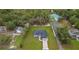 Aerial view of a single-story home with a well-manicured lawn, surrounded by lush greenery at 10262 Maybird Ave, Weeki Wachee, FL 34613