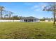 Spacious backyard featuring a well-maintained lawn and the back of a gray single-story home at 10262 Maybird Ave, Weeki Wachee, FL 34613