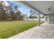 The covered patio overlooks a spacious, green backyard with mature trees and a serene atmosphere at 10262 Maybird Ave, Weeki Wachee, FL 34613